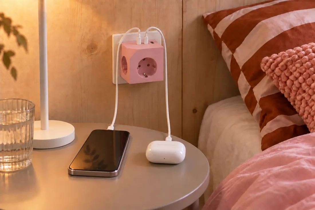 Dusty Rose am Nachttisch, ein Handy lädt